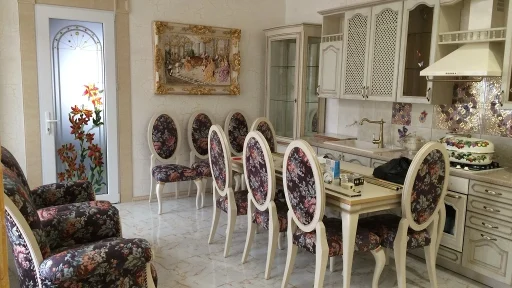 Столовый гарнитур со светлым столом и стульями, обитыми цветочной тканью