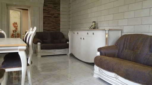 Уютная гостиная со светлой корпусной мебелью и коричневым диваном